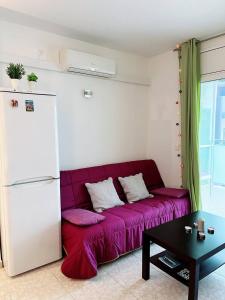 ein lila Sofa im Wohnzimmer mit Kühlschrank in der Unterkunft Salou quiet side Apartments in Salou