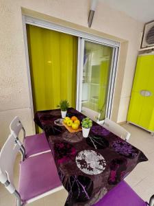 einen Tisch mit lila Stühlen und einen Tisch mit Obst darauf in der Unterkunft Salou quiet side Apartments in Salou