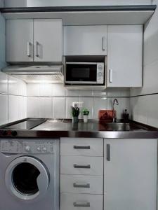 a kitchen with a sink and a washing machine at Salou quiet side Apartments in Salou