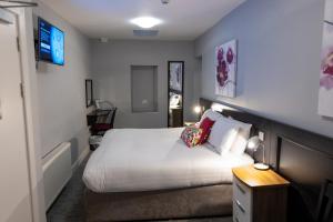 Habitación de hotel con cama y TV en Behan's Horseshoe Bar & Restaurant en Listowel