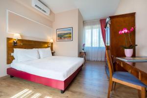 a hotel room with a bed and a desk at Certosa di Pontignano Residenza d'Epoca in Ponte A Bozzone