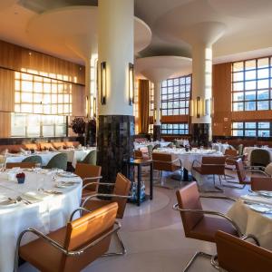 a restaurant with white tables and chairs and windows at Vincci Porto in Porto
