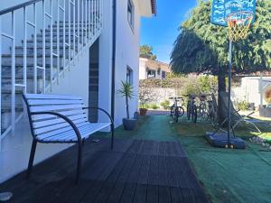 un banco en un porche con un aro de baloncesto en Cabedelo Seaside Guesthouse, en Viana do Castelo