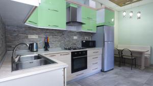 kuchnia z zielonymi szafkami i zlewem w obiekcie Stay Inn Apartments at Mashtots avenue 33-1 w Erywaniu