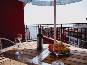 a table with a plate of fruit and a bottle of wine at Apartament Panorama - BastetBS in Sveti Vlas