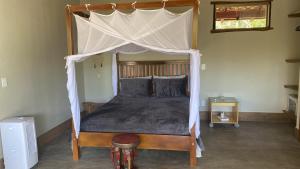 a bed with a canopy in a bedroom at Chalé Siriema na Chapada dos Veadeiros in Alto Paraíso de Goiás