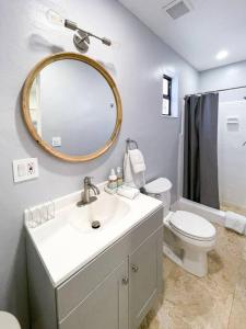 a bathroom with a sink and a toilet and a mirror at Private King Suite in Miami in Miami