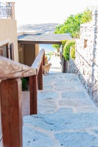 un gato caminando por una pasarela de piedra junto a un edificio en Villa Cavo d' Oro en Korissia