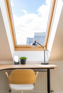 escritorio con ventana con lámpara y silla en MyFlat - Bright Apartment near Central Station, en Viena