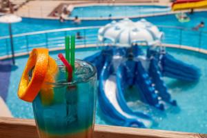 a drink on a table in front of a water park at Elounda Water Park Residence Hotel in Elounda