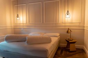Una cama en una habitación con dos luces. en Locanda Gaudemus Boutique Hotel, en Sistiana