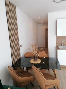 uma sala de jantar com uma mesa de vidro e cadeiras em Apartments Jakov em Makarska