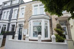 a house with a white front door on a street at Comfy-Stays - Ocean Road in South Shields