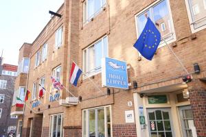 una señal de mejora del hotel en el lado de un edificio con banderas en Hotel Flipper Amsterdam, en Ámsterdam