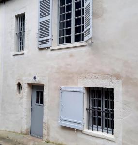 un edificio bianco con finestre e una porta di Maison d'Orion a La Réole