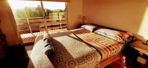 1 dormitorio con cama y ventana grande en Terrazas de Nahuascat en Santa Rosa de Calamuchita