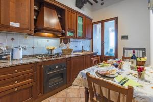 a kitchen with a table and a stove top oven at Appartamenti Panoramici Piazza delle Erbe in San Gimignano