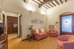 een woonkamer met 2 stoelen en een bank bij Appartamenti Panoramici Piazza delle Erbe in San Gimignano
