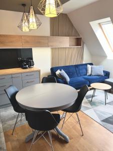 - un salon avec une table et un canapé bleu dans l'établissement Apartament 30, à Polanica-Zdrój