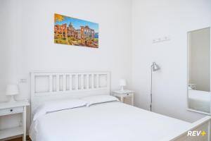 ローマにあるMecenate Apartment Colosseumの白いベッドルーム(白いベッド1台付)、バスルームが備わります。