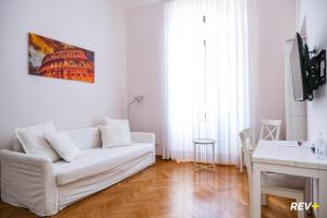 ローマにあるMecenate Apartment Colosseumの白いリビングルーム(白いソファ、テーブル付)