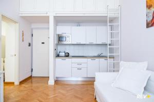 ローマにあるMecenate Apartment Colosseumのリビングルーム(白いソファ付)、キッチンが備わります。