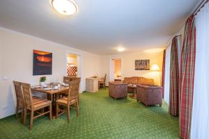 um quarto de hotel com uma mesa e cadeiras e uma sala de estar em Ziehrerhaus em Strobl