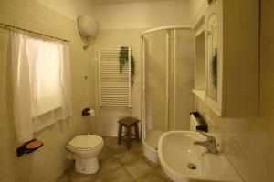 a white bathroom with a toilet and a sink at Agriturismo San Giuseppe in Gavorrano