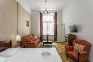 Habitación de hotel con 1 cama, 2 sillas y TV en The Spiski Palace Apartments, en Cracovia
