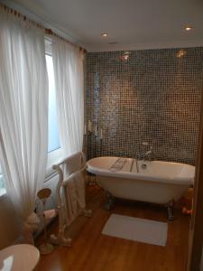 a bathroom with a bath tub and a window at Ugiebrae House Bed & Breakfast in Seahouses