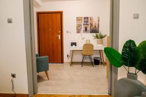 Zimmer mit einem Schreibtisch und einem Tisch mit einer Pflanze in der Unterkunft Newly Renovated Apartment 7 min walk from Acropolis in Athen