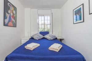 カステルデフェルスにあるHHBCN Beach Apartment Castelldefels #3の白い部屋の青いベッド1台(タオル付)