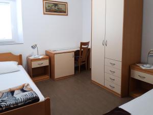 una piccola camera con letto, scrivania e di Apartments Igor a Capodistria