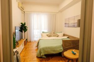 ein Schlafzimmer mit einem Bett, einem Sofa und einem TV in der Unterkunft Newly Renovated Apartment 7 min walk from Acropolis in Athen