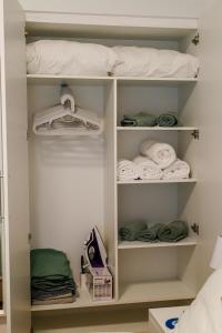 a closet with white shelves and towels at Newly Renovated Apartment 7 min walk from Acropolis in Athens