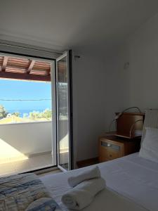 a bedroom with a bed and a large window at Villa Ampelaki "30 meters to beach" in Paleokastritsa