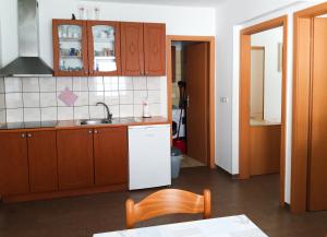 a kitchen with wooden cabinets and a sink at Apartments Igor in Koper
