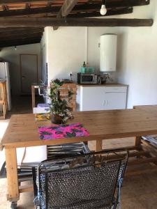 a wooden table in a room with a kitchen at Quinta das Caçadoras - Animal lovers only in Palmela