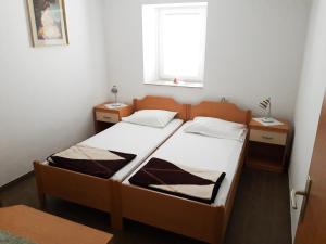 una piccola camera con un letto e due comodini di Apartments Igor a Capodistria