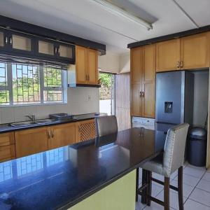 eine Küche mit einer schwarzen Arbeitsplatte und einem Kühlschrank in der Unterkunft Tinley Manor Beach House in Tinley Manor