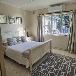 Un dormitorio con una cama grande y una ventana en Tinley Manor Beach House, en Tinley Manor