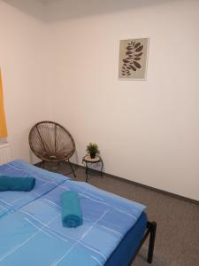 1 dormitorio con 1 cama azul y 1 silla en Vila Pavlínka , apartmány Losiny en Velké Losiny