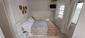 a small bedroom with a bed and a window at Floripa Hostel in Florianópolis