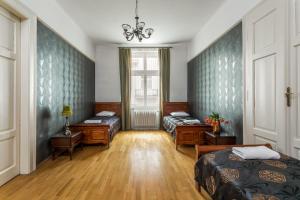 1 Schlafzimmer mit 2 Betten und einem Kronleuchter in der Unterkunft The Spiski Palace Apartments in Krakau