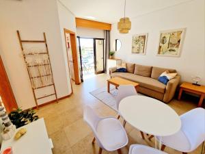 a living room with white chairs and a couch at ZARCO - Apartment in Vilamoura with 2 Pools near the Beach & the Marina in Quarteira