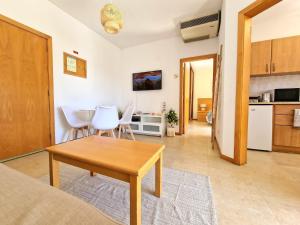 uma sala de estar com uma mesa e uma cozinha em ZARCO - Apartment in Vilamoura with 2 Pools near the Beach & the Marina em Quarteira