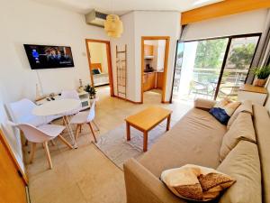 salon z kanapą i stołem w obiekcie ZARCO - Apartment in Vilamoura with 2 Pools near the Beach & the Marina w mieście Quarteira