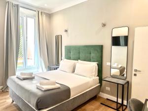 a bedroom with a large bed and a mirror at AD Suites Tritone in Rome