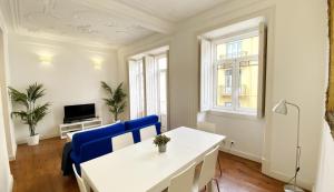 - un salon avec une table blanche et des chaises bleues dans l'établissement House On The Hill Lisbon, à Lisbonne