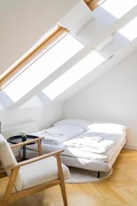 1 dormitorio con cama, silla y tragaluz en MyFlat - Bright Apartment near Central Station, en Viena